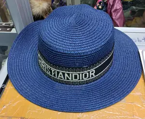 Blue woven fedora hat with wide brim and black band featuring Christian Dior logo.