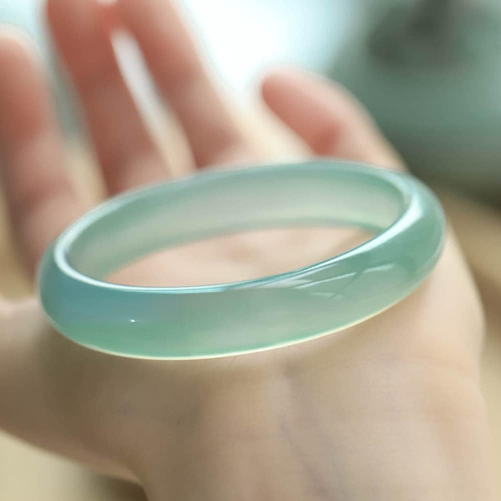 Light Bluish‑Green Jade Bangle Bracelet Translucent jade bangle in light bluish‑green hue with glossy surface, worn on wrist.