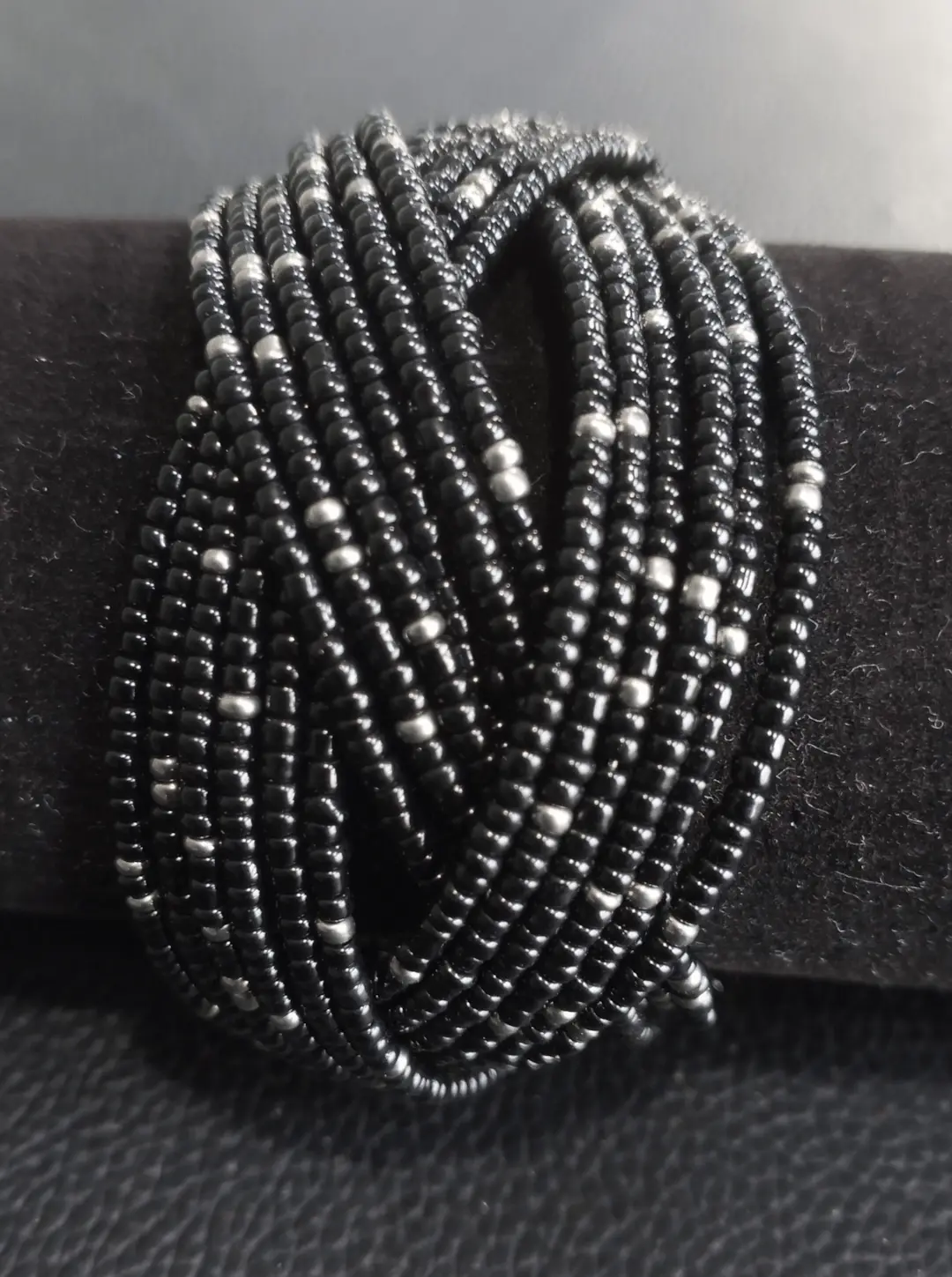 Beaded cuff wrap bracelet in black beads with silver accents.