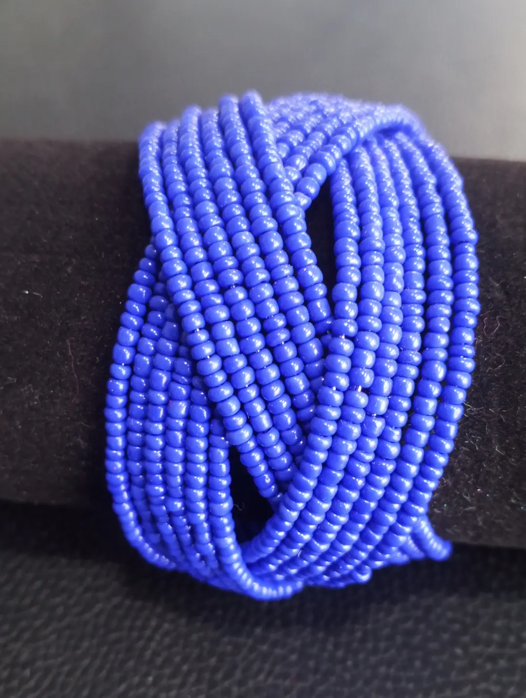 Handcrafted beaded cuff wrap bracelet in vibrant blue tones.