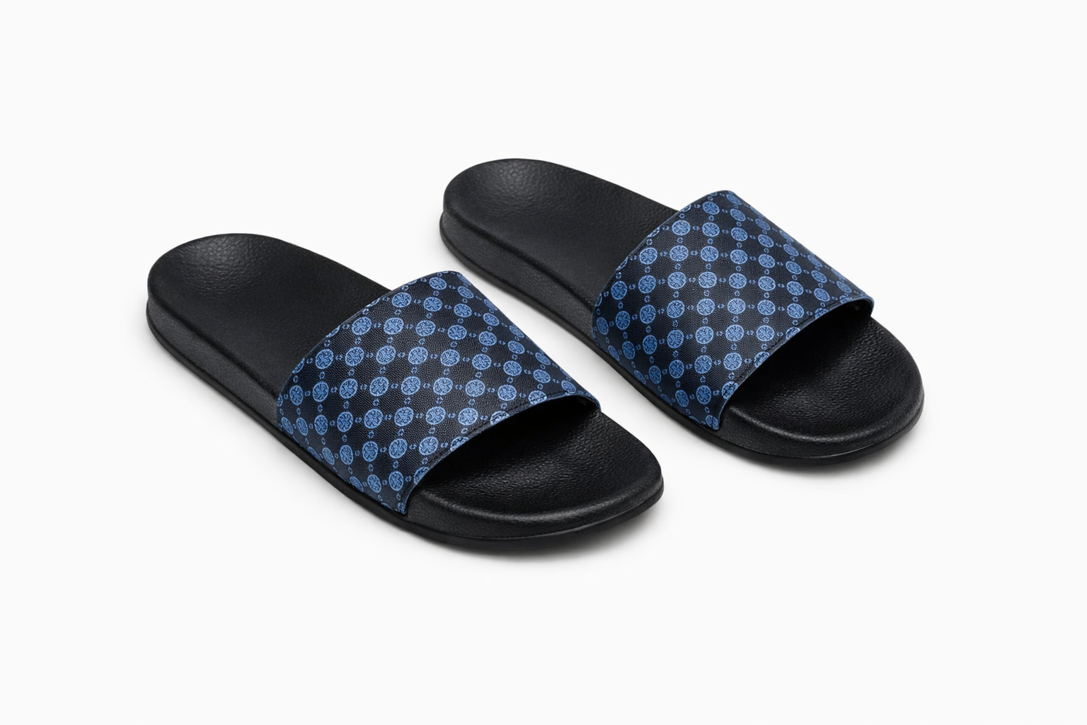 Black sole slide sandals with wide blue strap featuring repeating lighter blue circular pattern.