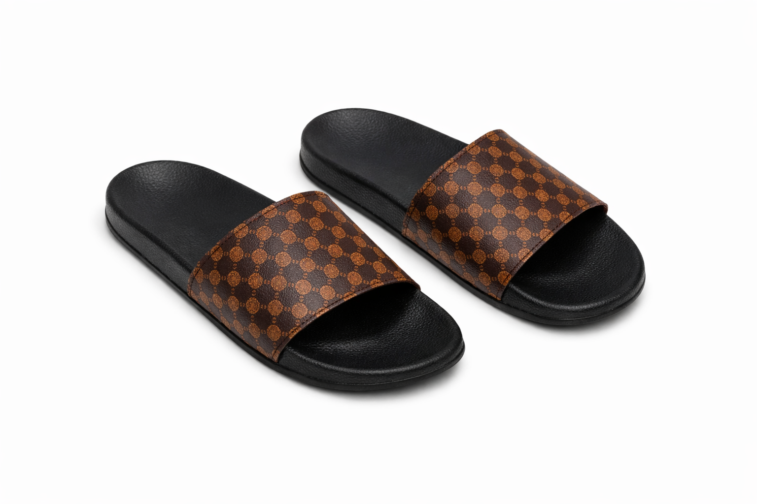 Black sole slide sandals with wide brown strap featuring repeating geometric circular pattern.