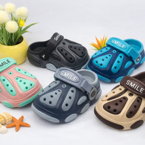 Cover image showing five pairs of children’s crocs in Nairobi Kenya. Variants include pink with mint green, black with gray, navy with blue, dark gray with light gray, and beige with brown. Each pair features SMILE strap branding, ventilation holes, and playful rubber clog design, displayed with summer‑themed decorations.