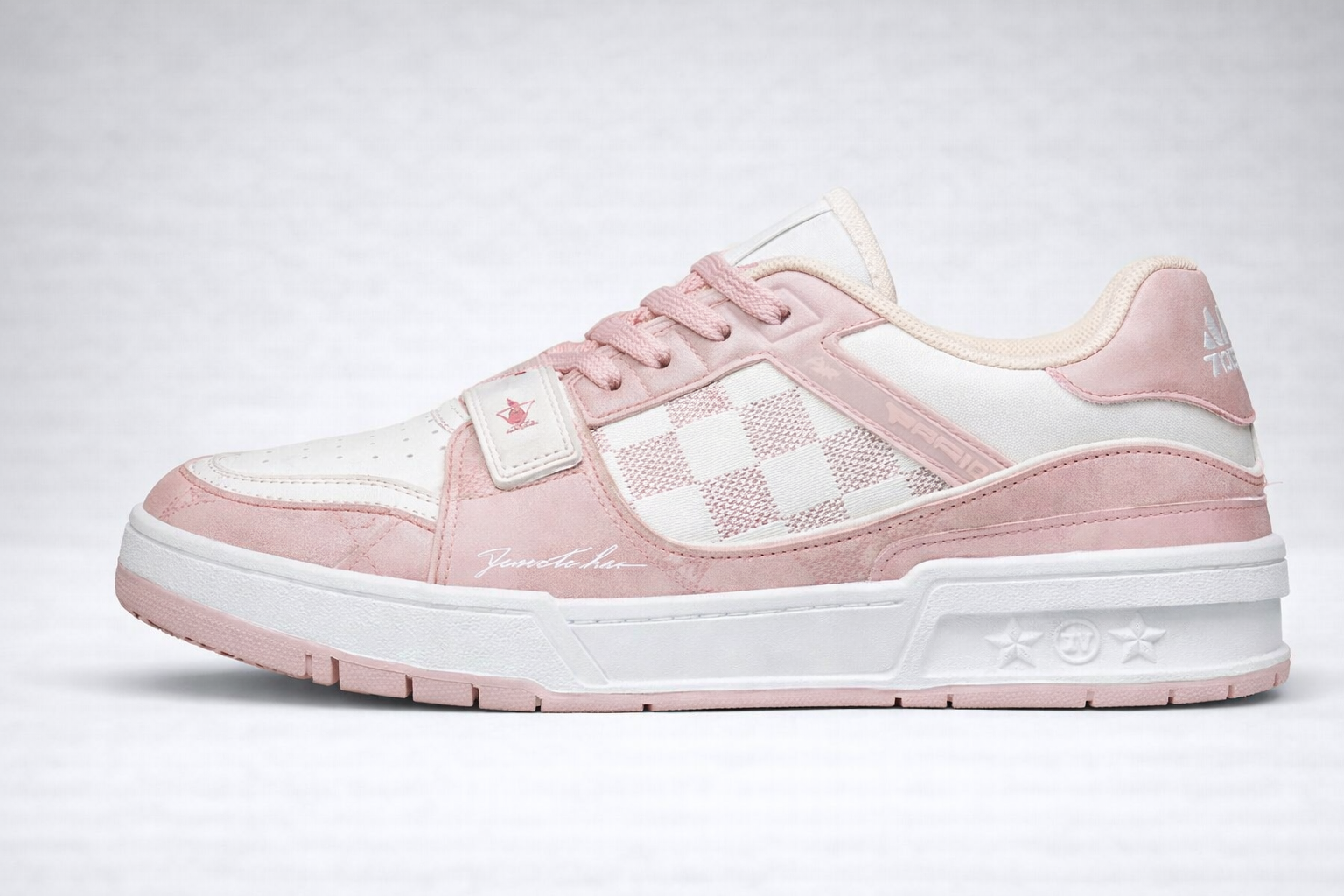 Pastel pink and white sneaker with checkerboard midsection, suede overlays, and embossed star symbols on sole
