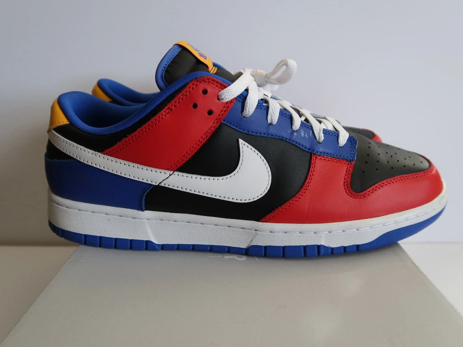Nike Dunk Low Tennessee State University sneaker with red, blue, black, white, and yellow panels, white swoosh, white laces, and blue outsole Nairobi Kenya.