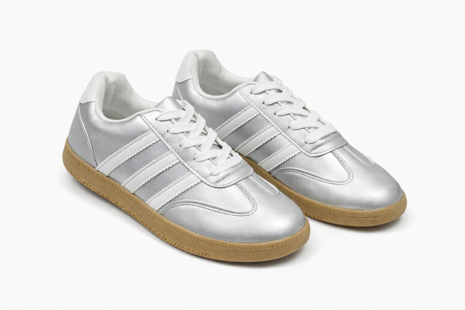 Silver sneakers with white stripes, white laces, and gum sole.