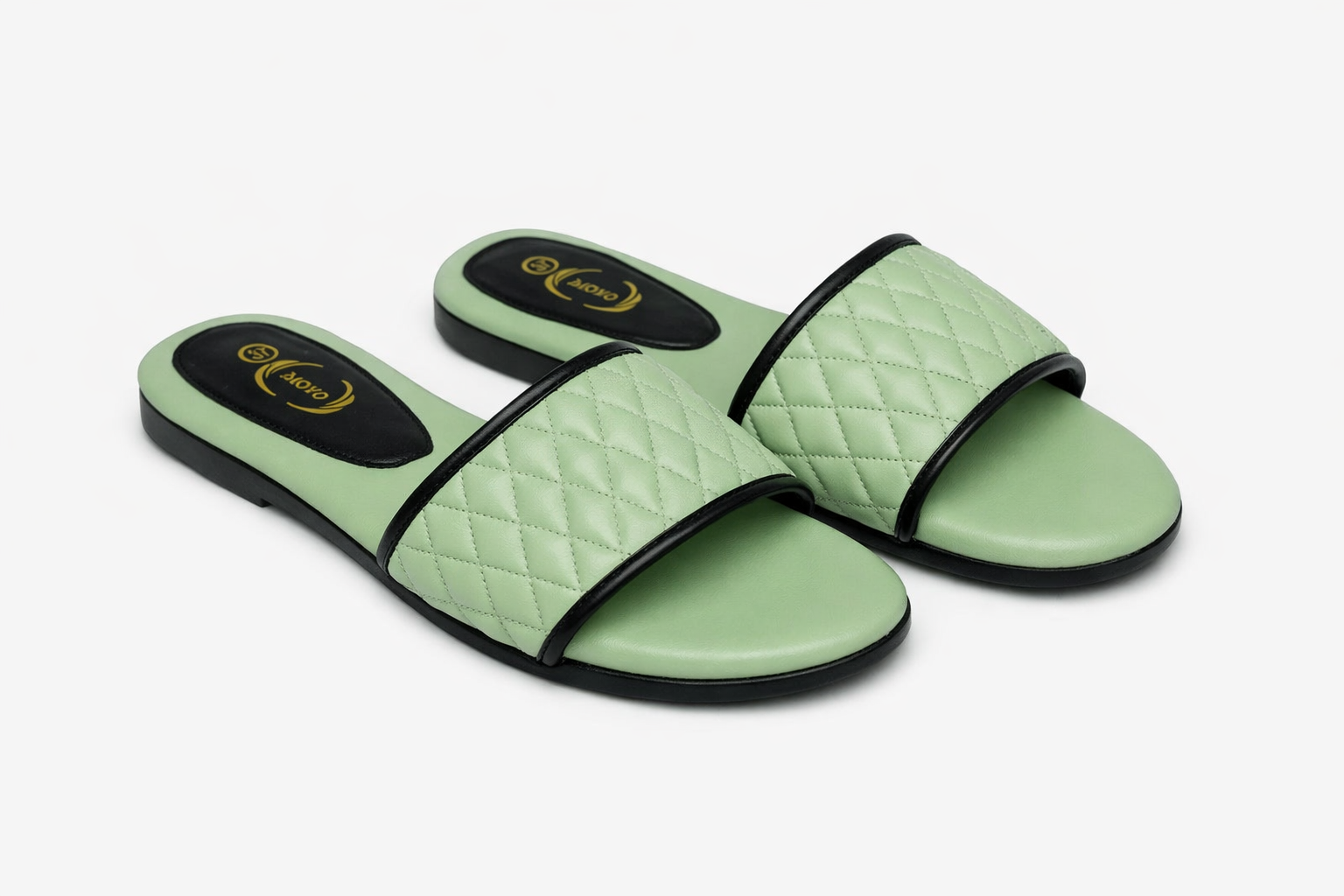 Light green quilted women’s slide sandals with diamond‑pattern straps, black trim, trendy summer footwear in Nairobi Kenya.