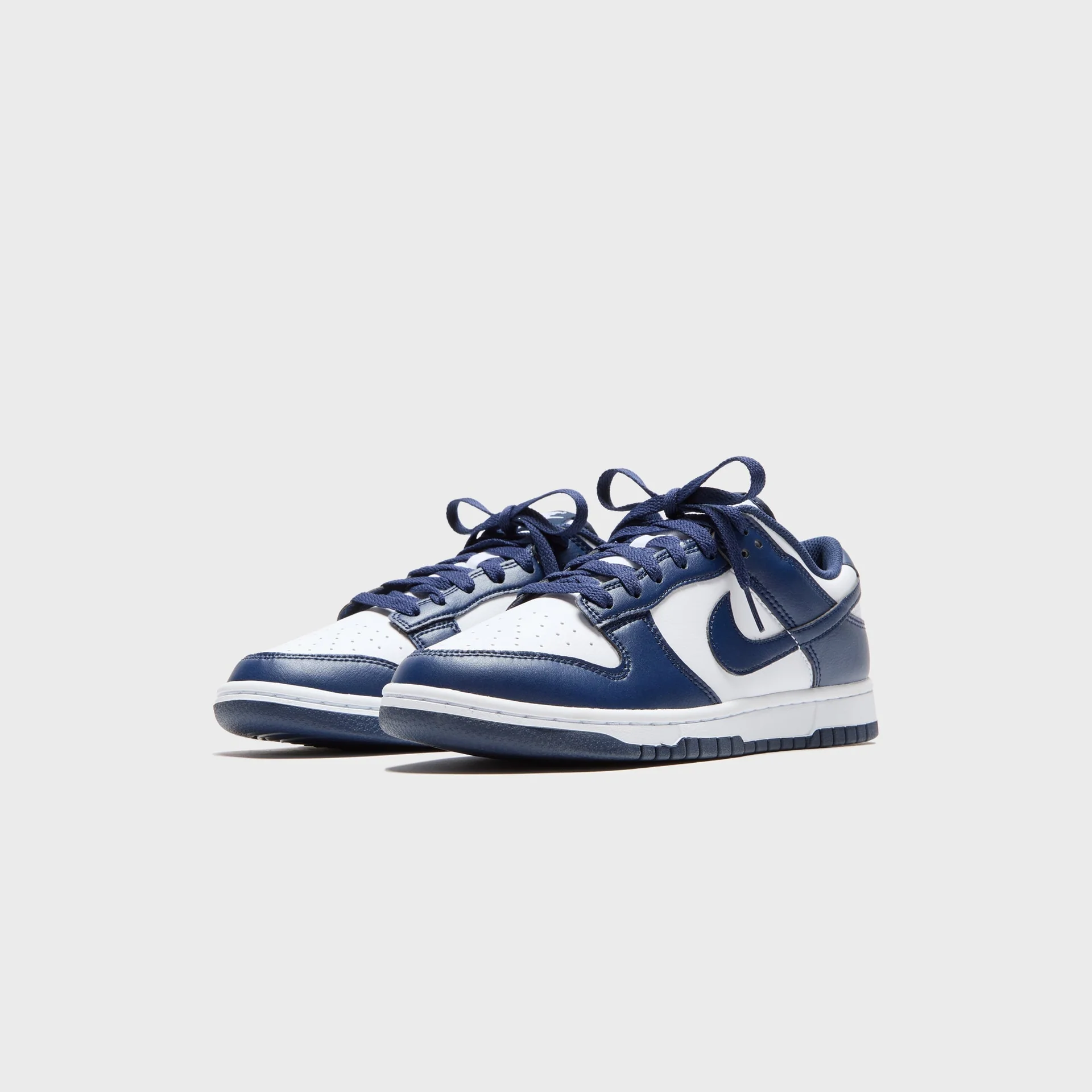 Nike Dunk Low Retro White Leather with Navy Blue Swoosh Sneakers Nairobi Kenya Nike Dunk Low Retro sneaker with white leather base, navy swoosh, navy overlays, navy laces, and white midsole Nairobi Kenya.