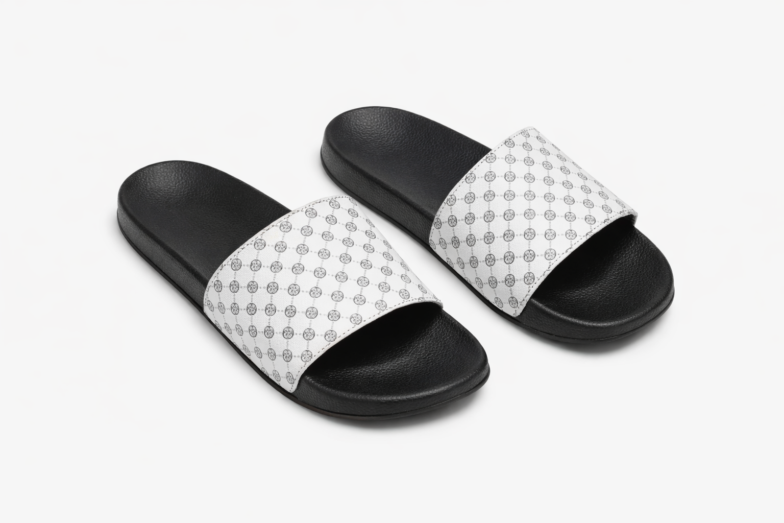 Black sole slide sandals with wide brown strap featuring repeating geometric circular pattern.